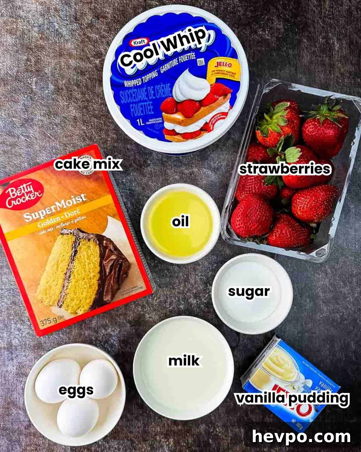 Ingredients for strawberry shortcake parfaits labeled and placed on a table.