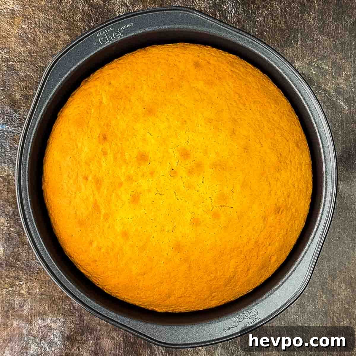 The baked golden cake in a round baking dish.