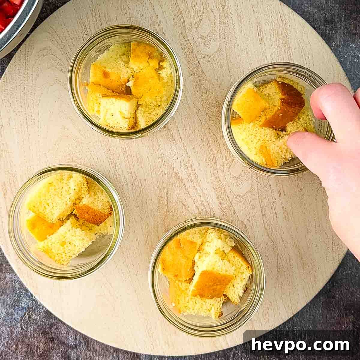 The cubes of cake being placed in small jars.
