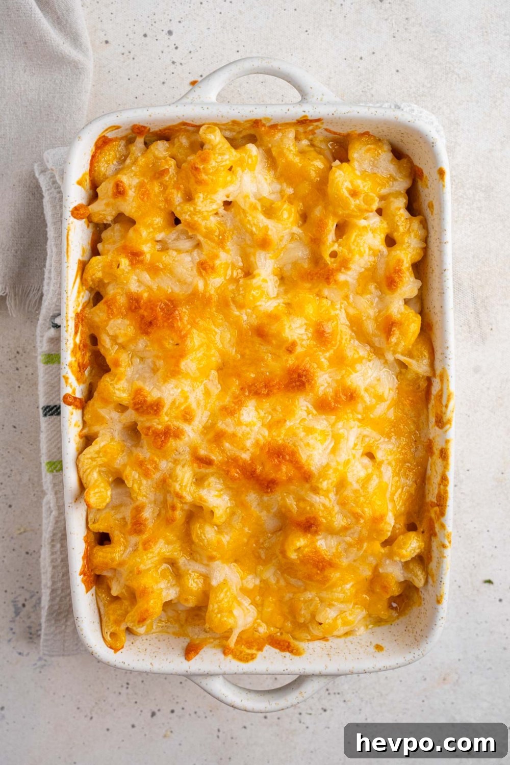 Tini’s Viral TikTok Mac and Cheese Recipe 10 A white ceramic baking dish with baked Tini's mac and cheese. The dish is on a white counter with a white cloth napkin.