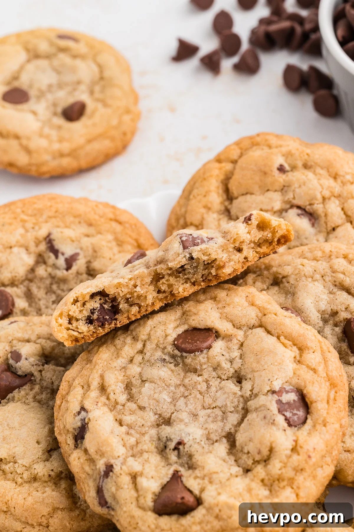 Gluten-Free Chocolate Chip Cookies Loved by Non-GF Eaters 3 Gluten free chocolate chip cookies on a plate with one broken in half so you can see the inside.