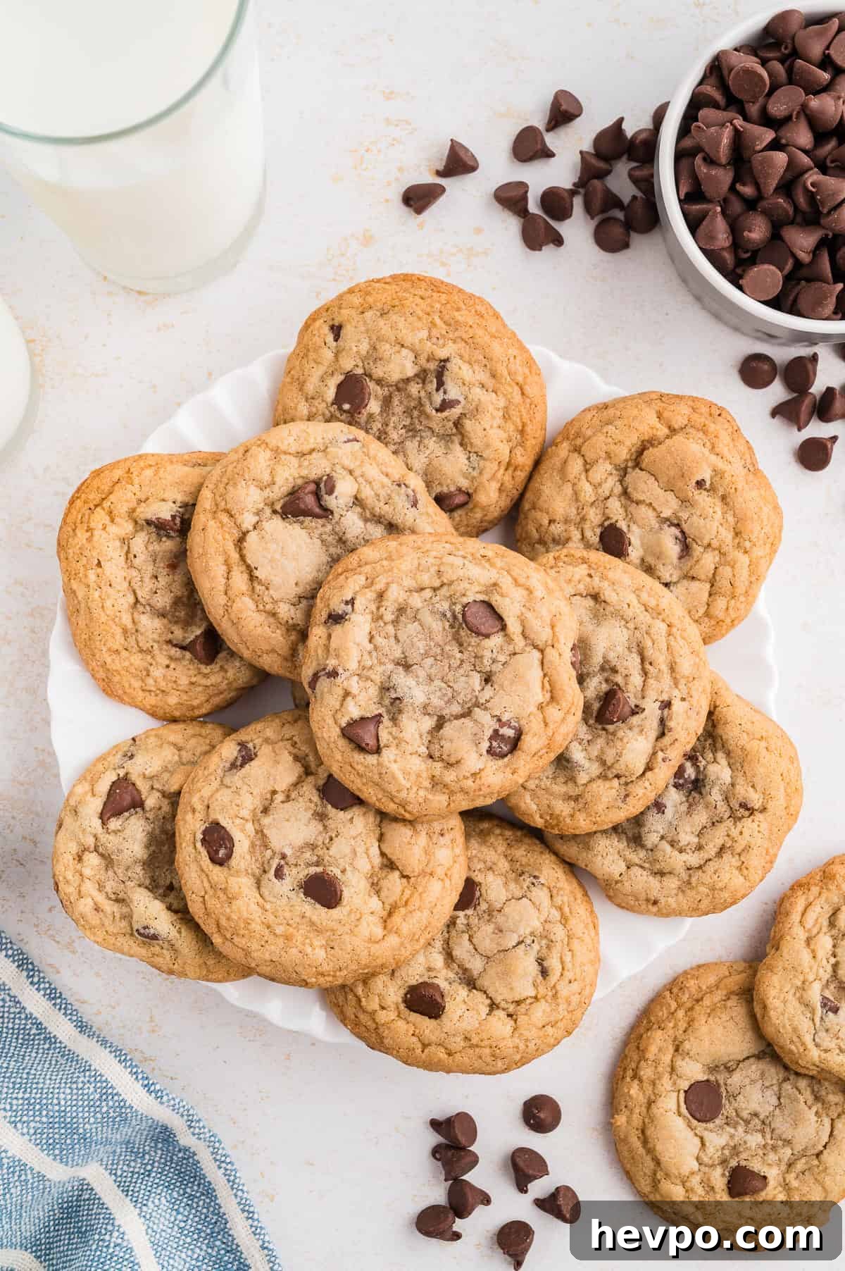Gluten-Free Chocolate Chip Cookies Loved by Non-GF Eaters 4 Gluten free chocolate chip cookies on a plate with chocolate chips off the plate by the side.