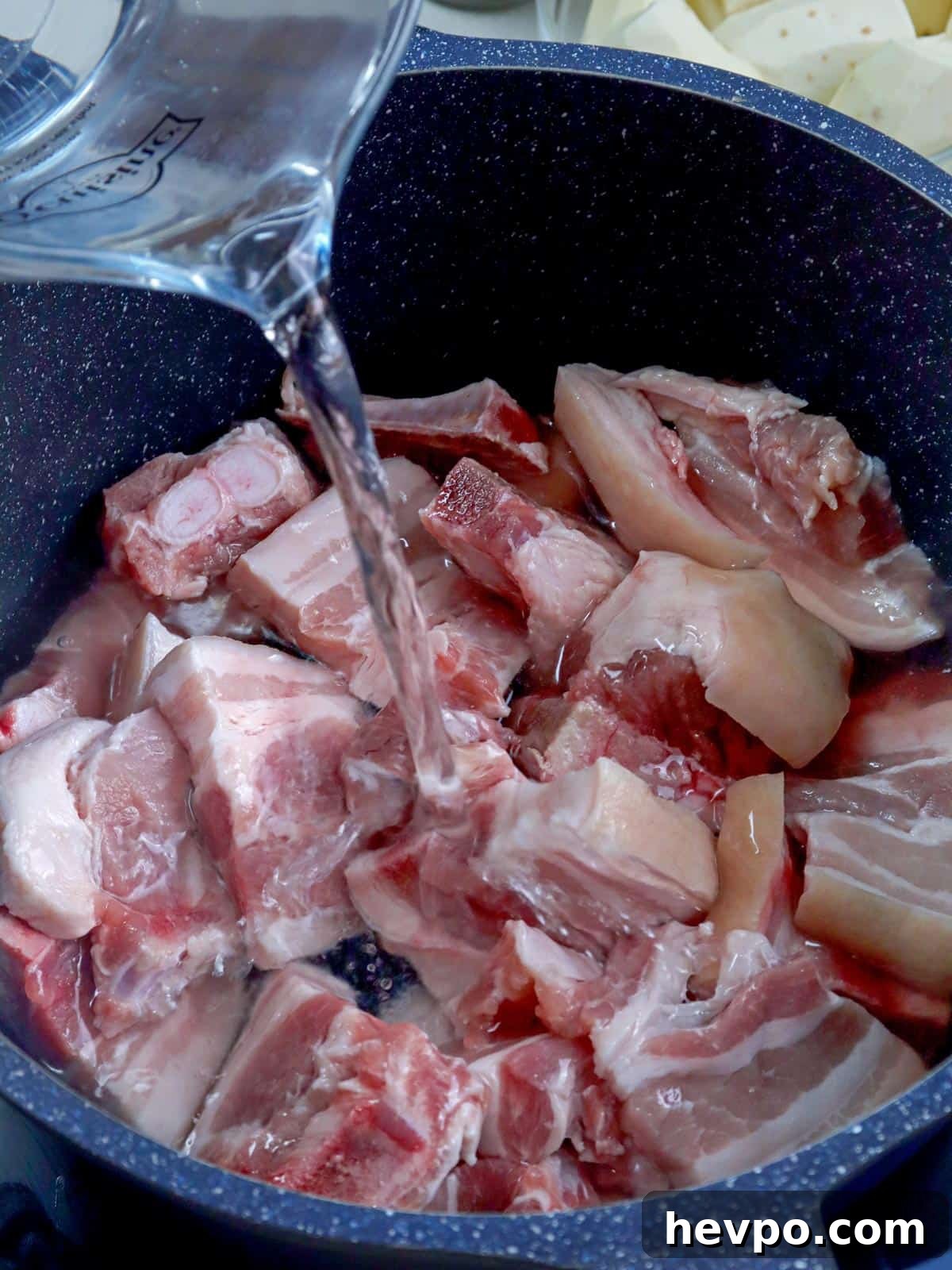 Bulanglang Pork Stew: Filipino Spiced Pork in Sour Broth 4 pouring water to a pot of pork