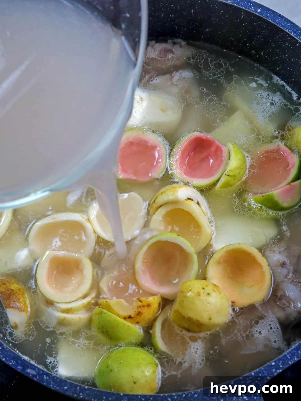 Bulanglang Pork Stew: Filipino Spiced Pork in Sour Broth 5 pouring guava juice in a pot of bulanglang