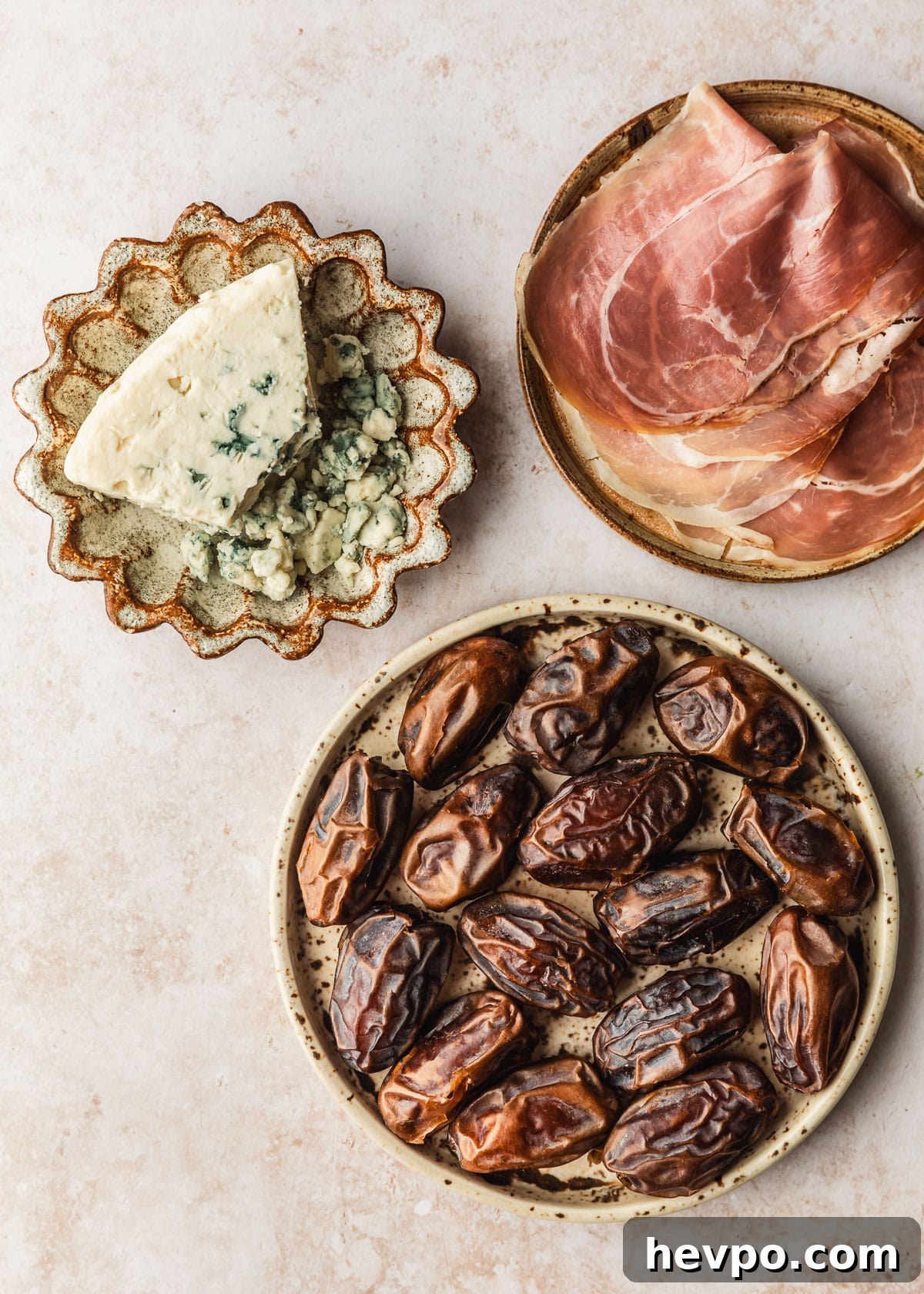 Prosciutto-Wrapped Dates with 3 Simple Ingredients 3 Brown plates of blue cheese, dates, and prosciutto on a tan counter.