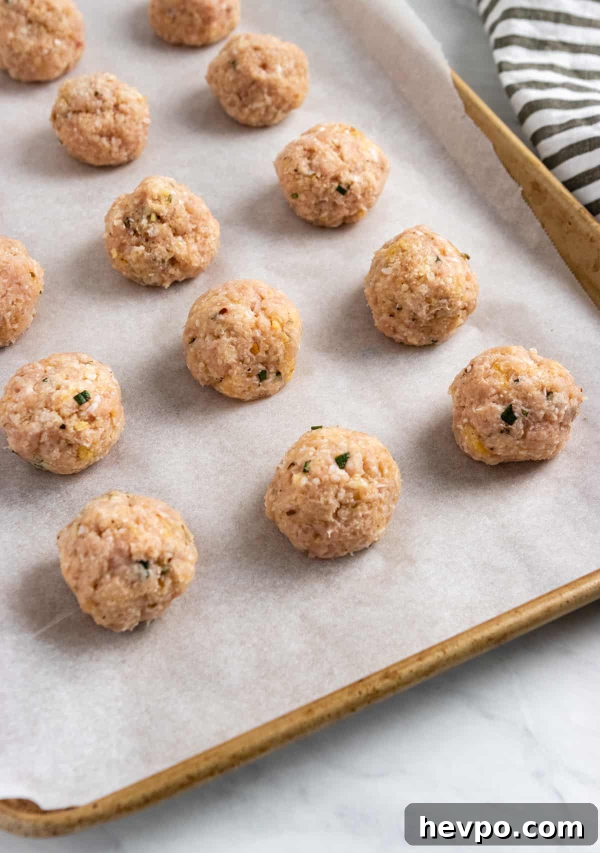Rolled meatballs on baking sheet.