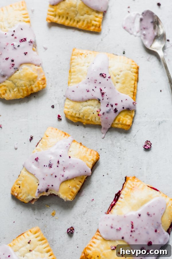 Four poptarts Top down four homemade blueberry hand pies topped with purple icing.