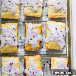 Homemade Blueberry Pop-Tarts Recipe: Flaky, Jam-Filled Pastries 5 Blueberry pop tarts on a cooling rack.