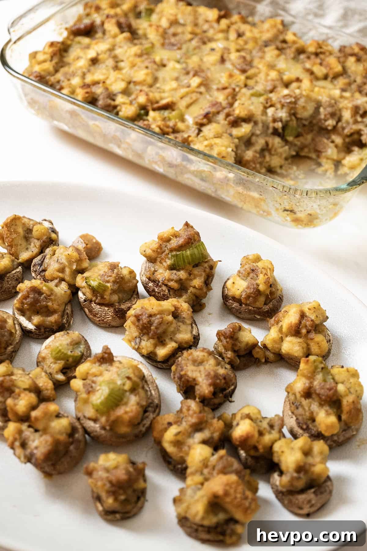 Italian sausage stuffing baked in a glass baking pan with stuffed mushrooms.