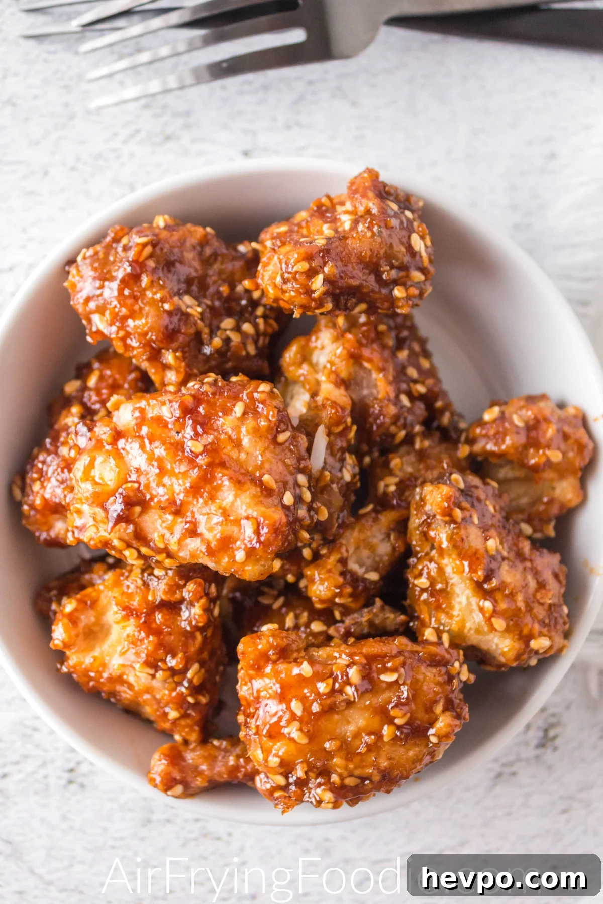 Air fried sesame chicken in a white bowl ready to serve.