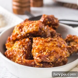 Air fried sesame chicken in a white bowl and ready to serve.