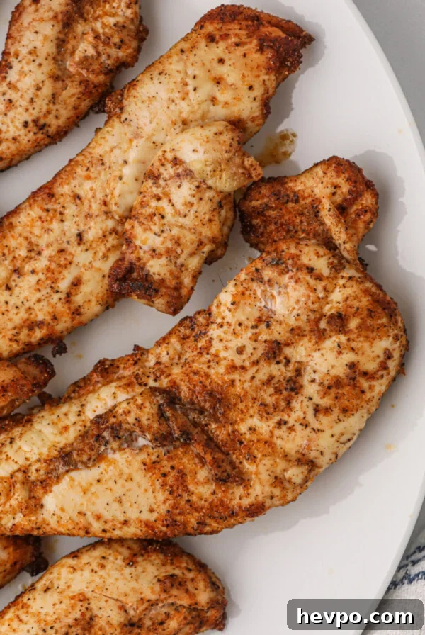Air fryer grilled chicken tenders on a white plate.