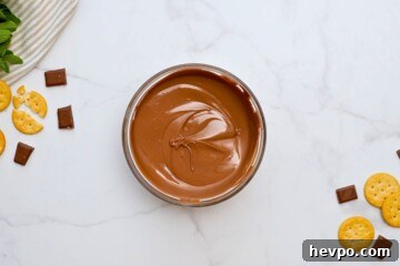 Melted chocolate in a glass bowl with crackers