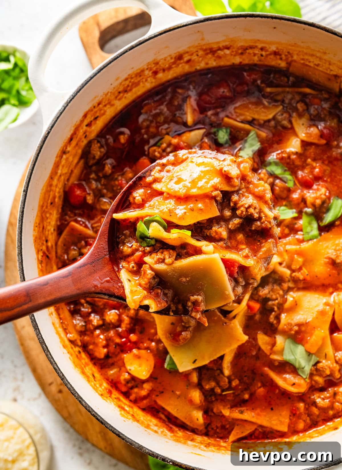 lasagna soup in a pot with a spoon raising a scoop up.
