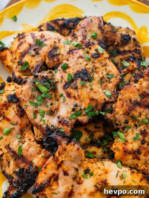 Chicken on a serving dish with garnish.
