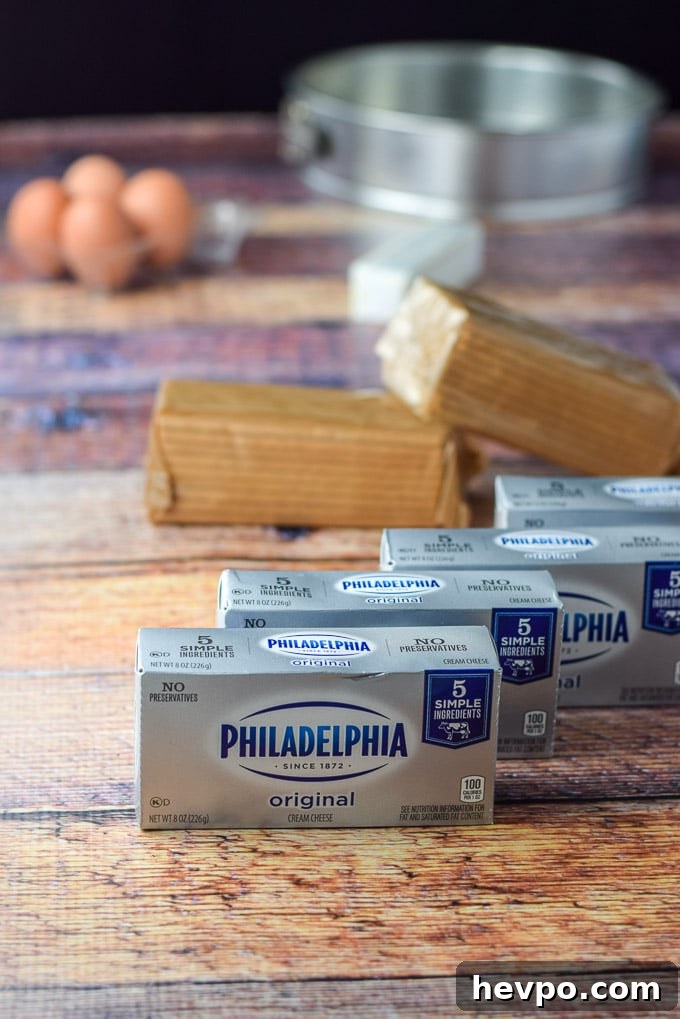 Cream cheese, graham crackers, butter and eggs on a wooden table