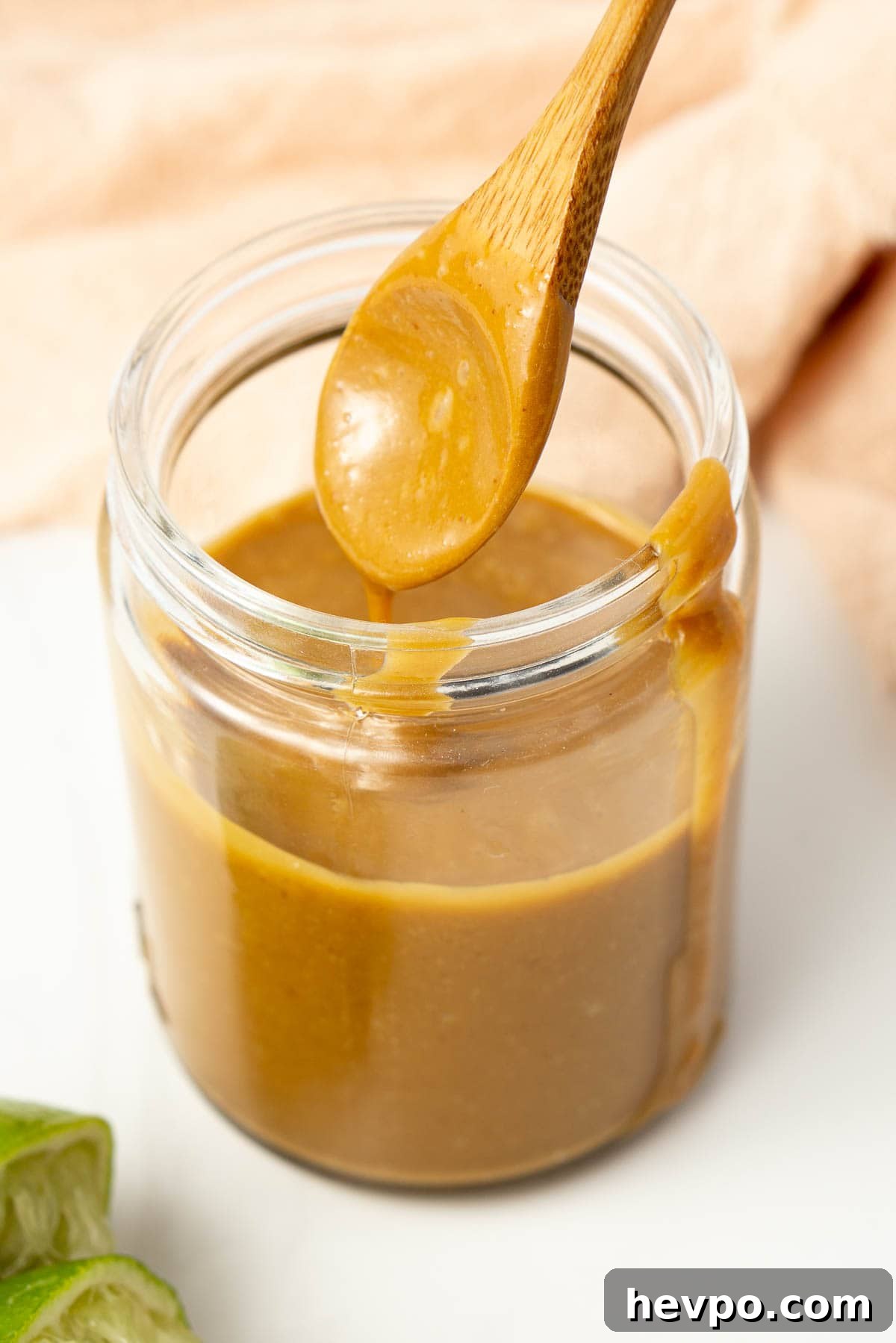Creamy Peanut Satay Sauce Recipe for Grilling & Dipping 6 Peanut sauce in a glass jar with a spoon.