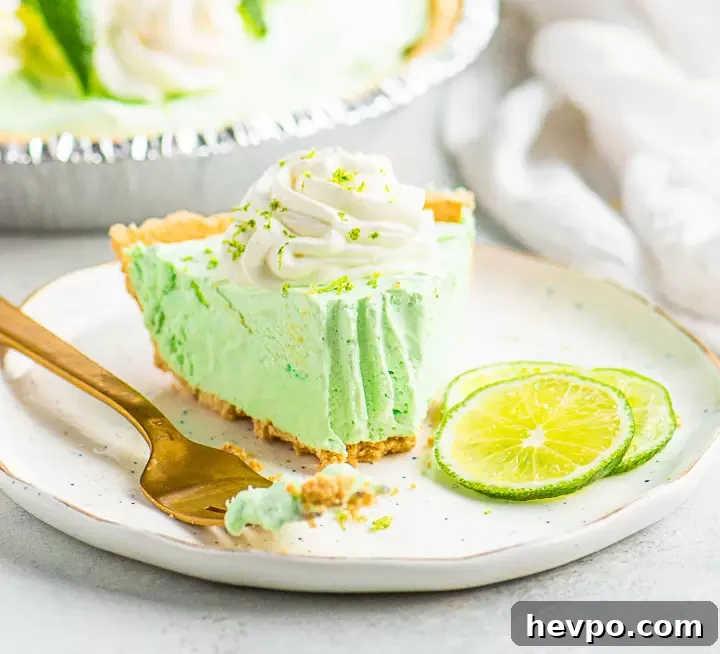 Margarita Pie Recipe: Zesty Lime and Tequila Tart 4 slice of pie on a plate with a bite removed in between a fork and three thin slices of lime