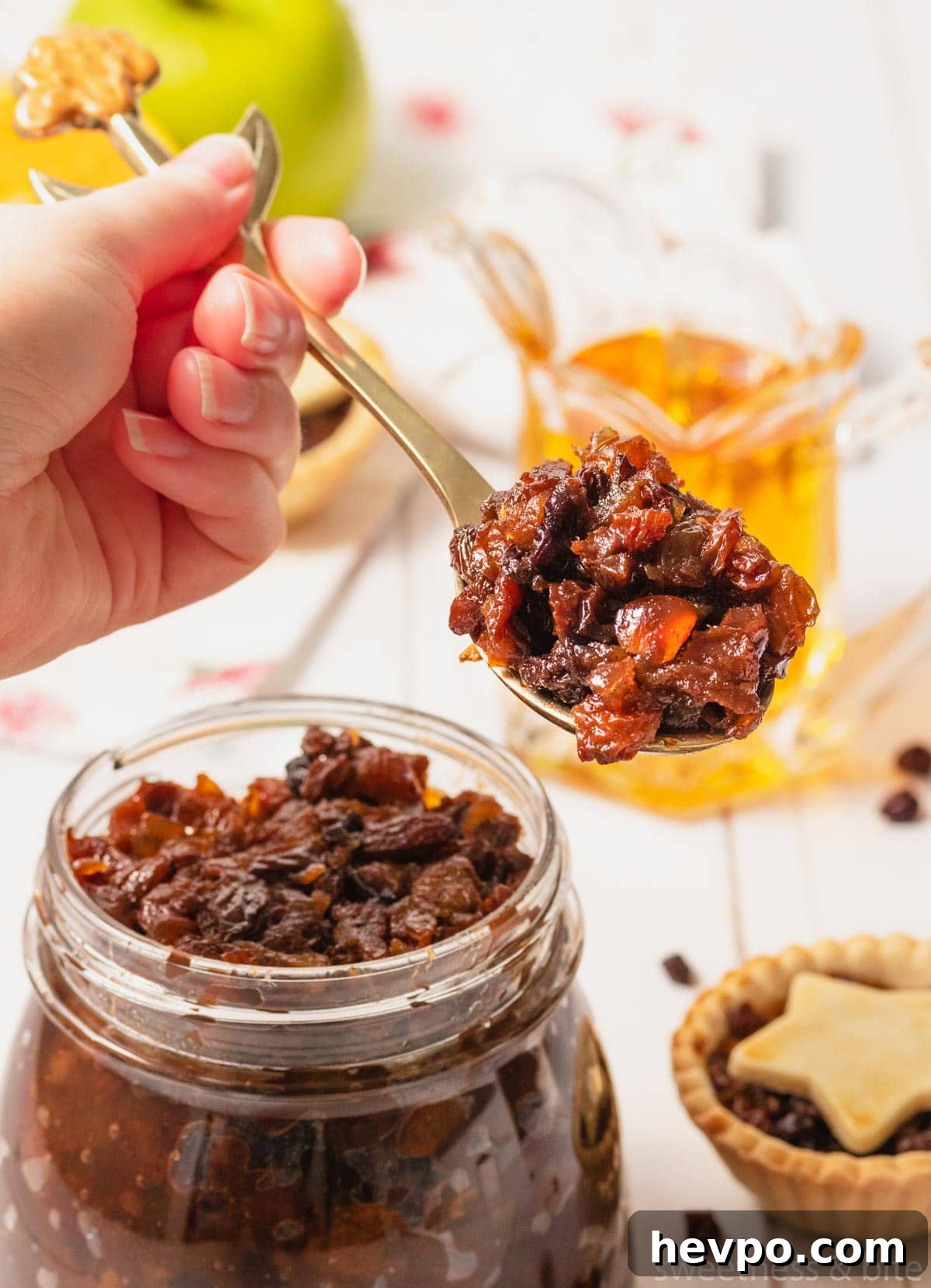A hand holding a spoonful of quick fruit mince.