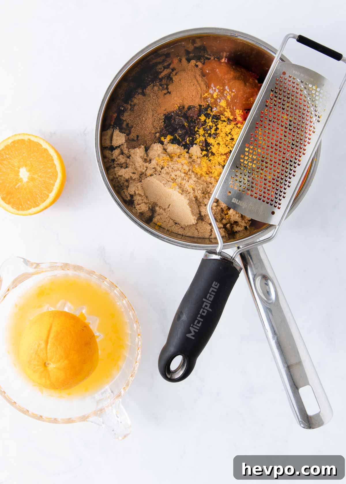 The orange being zested and juiced and added to the pan.