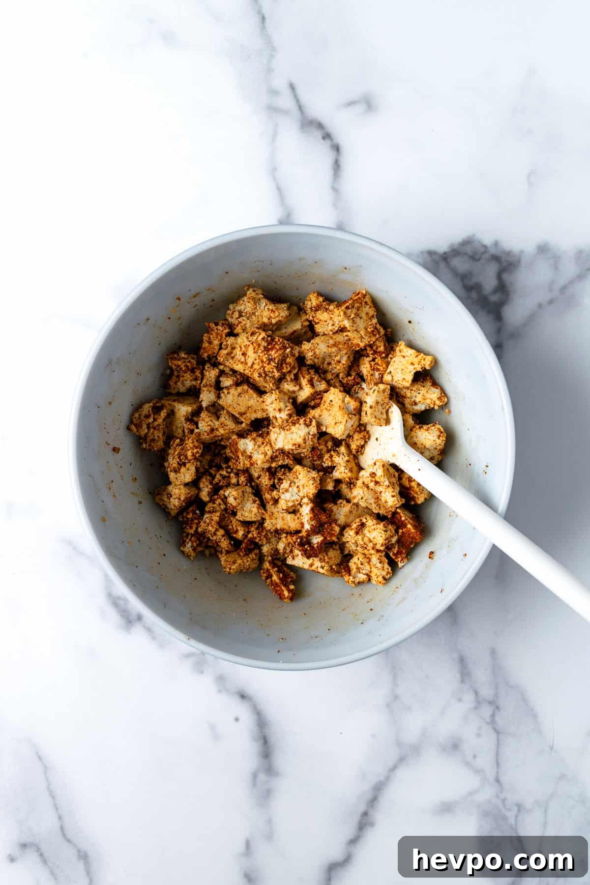 Tofu chunks with taco seasoning in a bowl.