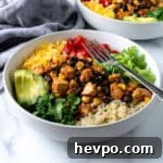 Tofu Burrito Bowls in a white bowl with a fork.