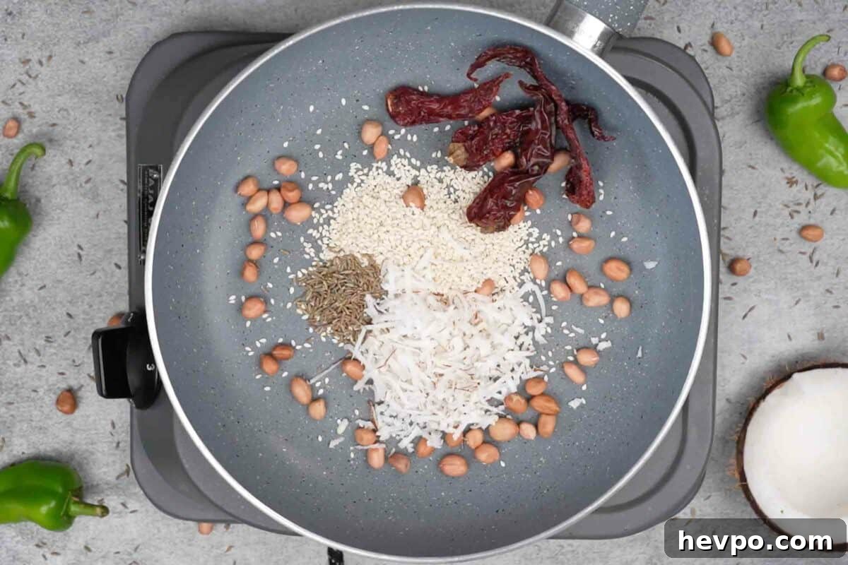 Mirchi Ka Salan (Biryani Salan) Recipe — Spicy Hyderabadi Chili Curry 5 Peanuts, sesame, cumin, coconut and dry red chilies added to a pan.