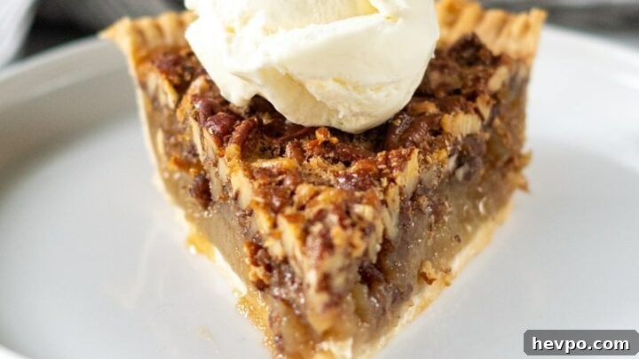 a slice of gluten-free pecan pie topped with a scoop of vanilla ice cream