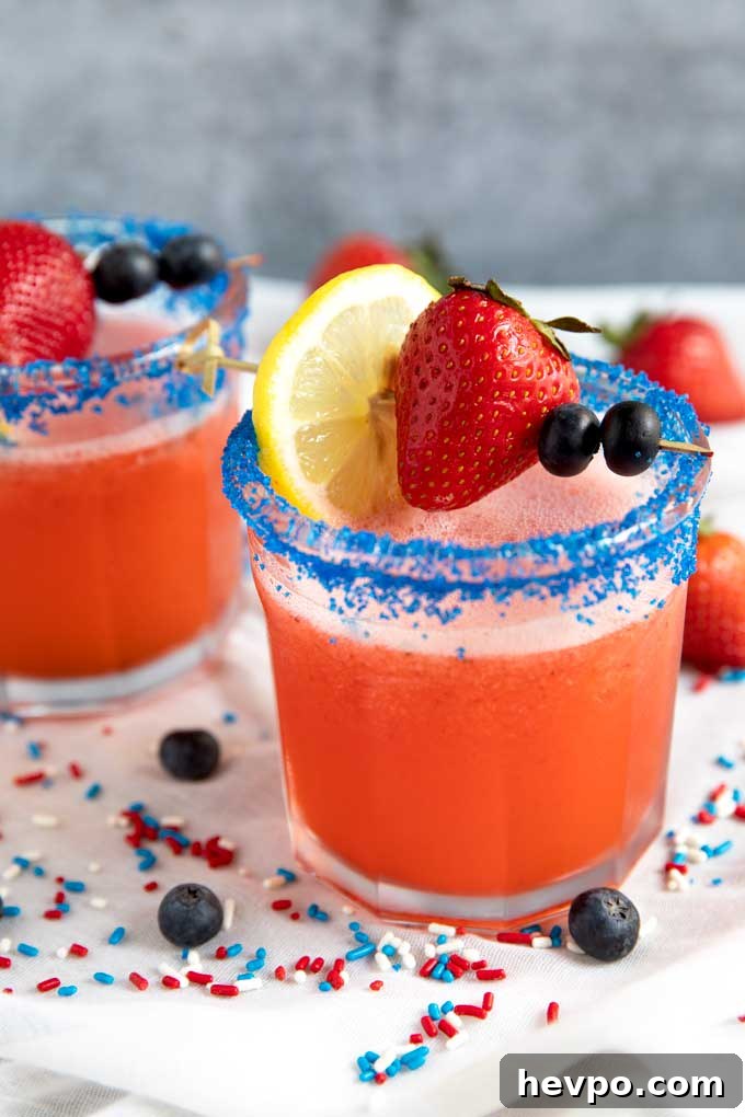 Strawberry Lemonade Vodka Cocktail Recipe for Summer Sipping 8 Two glasses with blue sugar on the rim and filled with Lemonade vodka cocktail