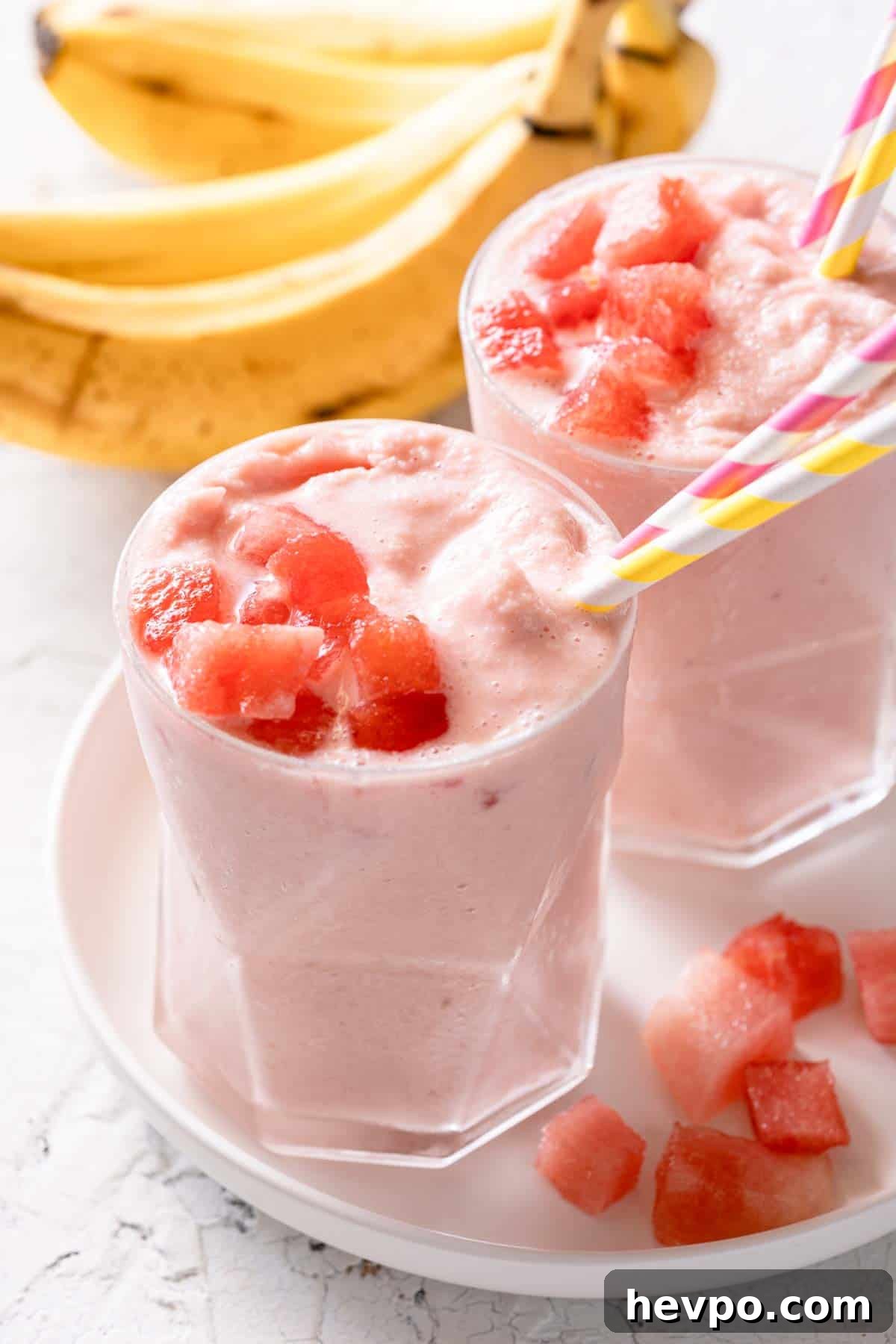 two banana watermelon smoothies on white plate