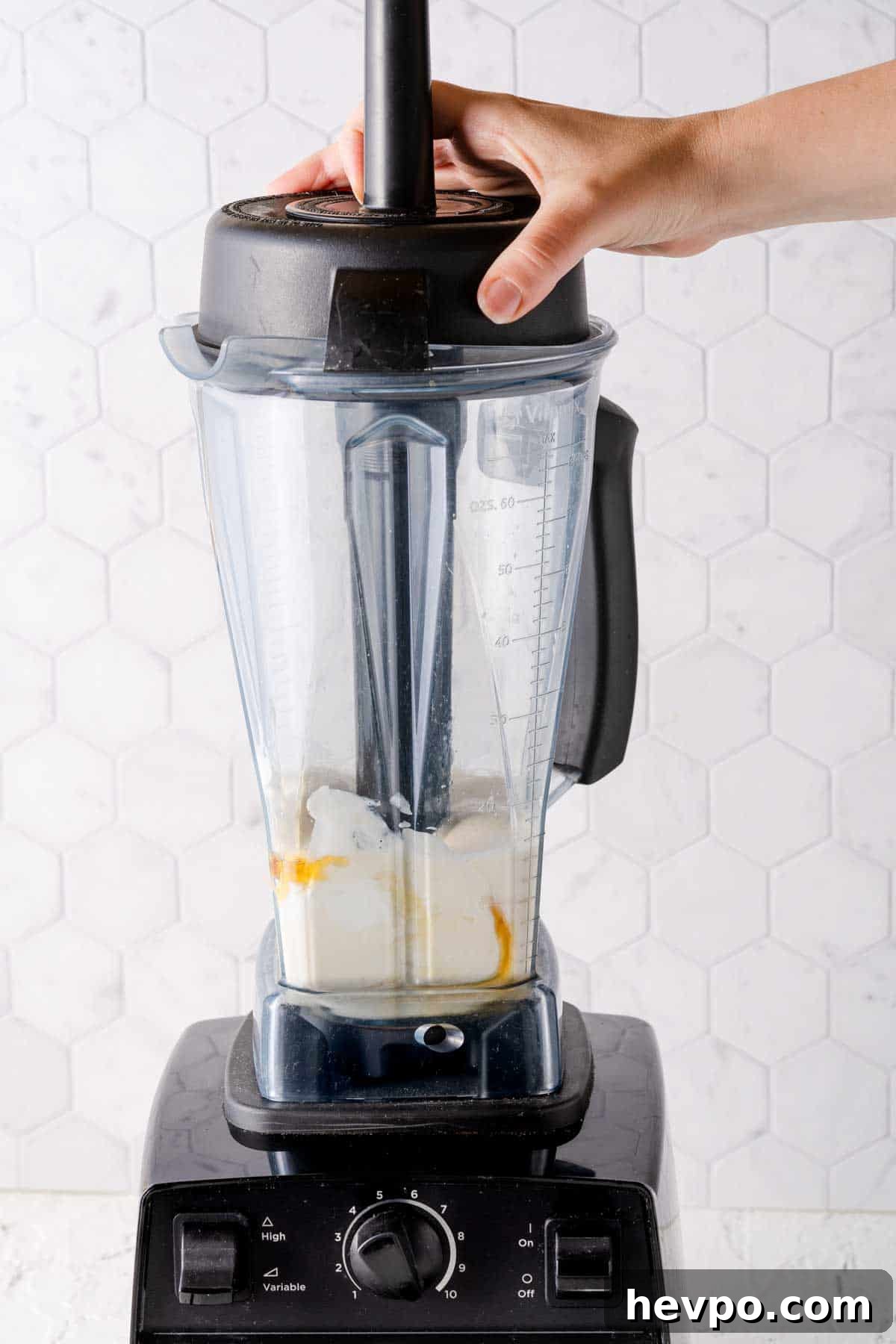 banana, milk, yogurt and honey being blended in blender