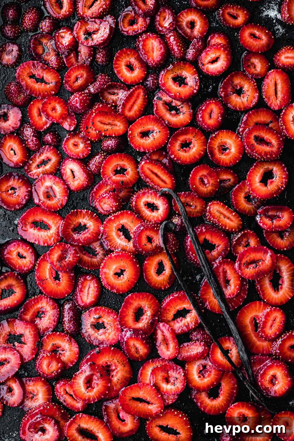 Roasted Strawberries: How to Cook and Use Them for Bold Flavor 11 sliced strawberries with sugar, salt and vanilla beans on a baking sheet