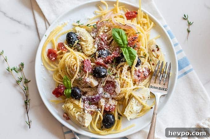 A dish of pasta topped with basil and parmesan cheese.