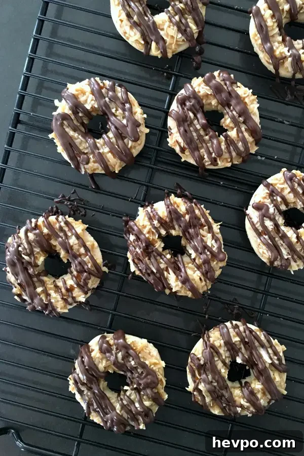 overhead view of Samoa Girl Scout Cookies (shortbread with coconut caramel and a chocolate drizzle) drying on a black cooling rack.