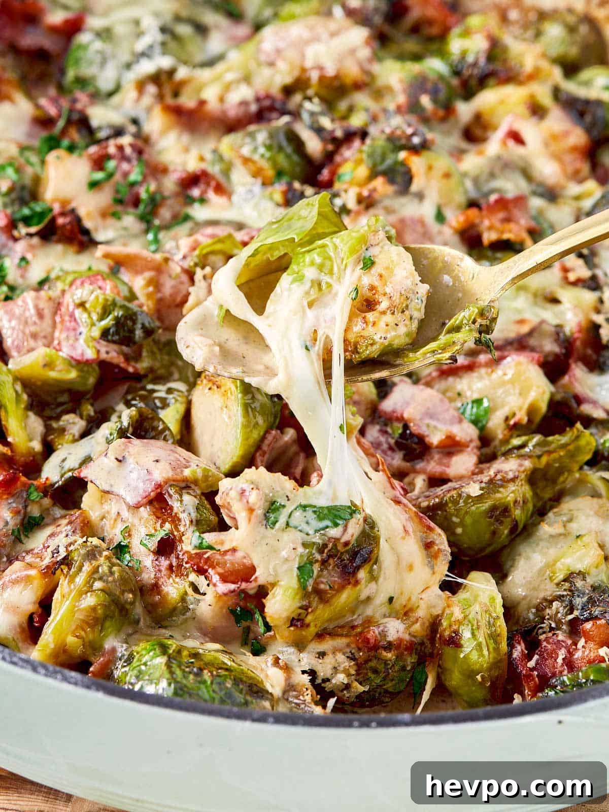 Crispy Bacon Brussels Sprouts Recipe: Roasted with Garlic and Honey 2 Close-up of cheesy Brussels sprouts and bacon with gooey mozzarella stretching from the pan