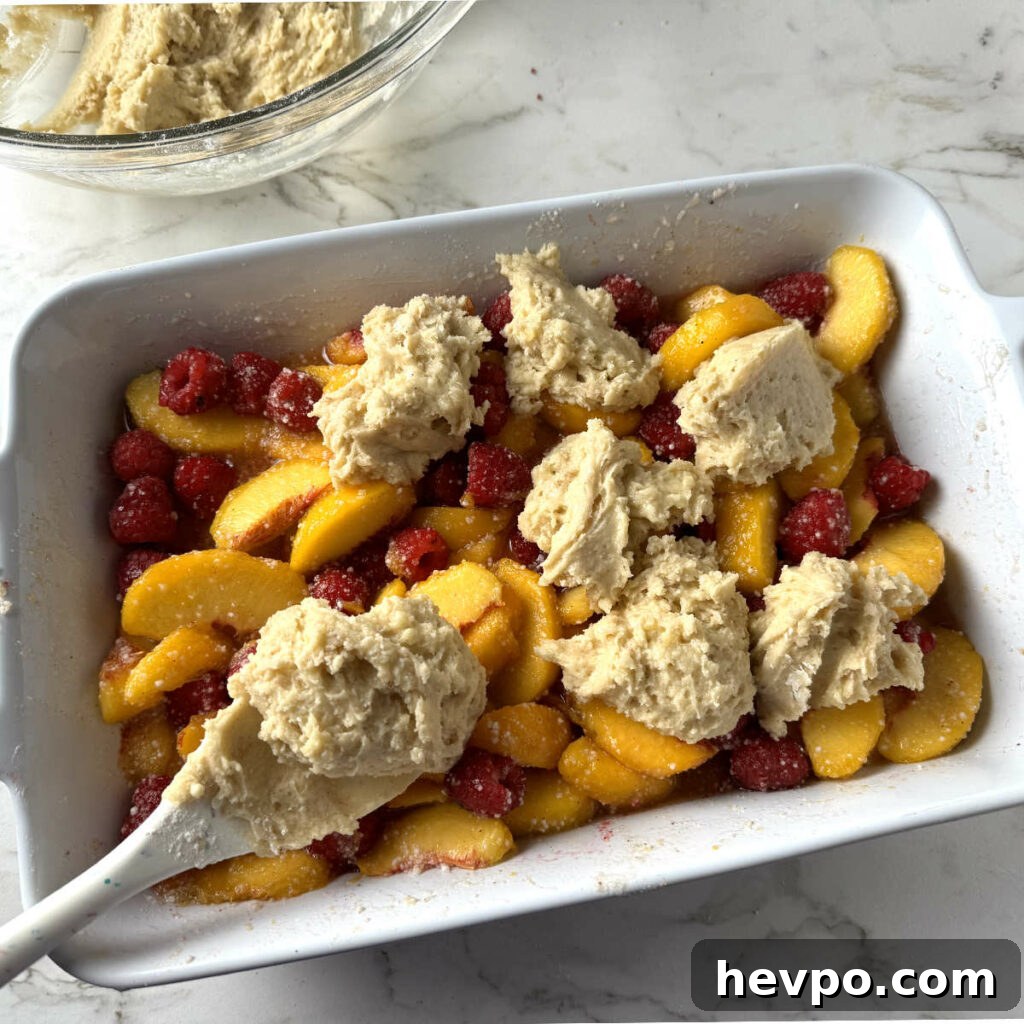 Raspberry and Peach Cobbler with Buttermilk Drop Biscuits 7 Adding drop biscuits on top of the cobbler filling.