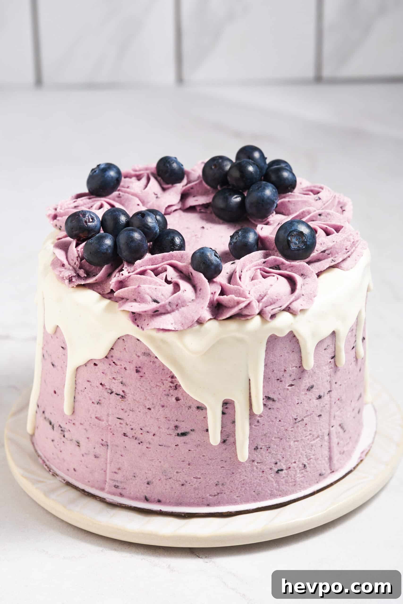 A blueberry layer cake topped with fresh blueberries.